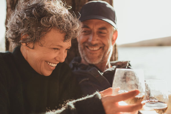 mature couple enjoying drinks on the beach