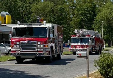two fire trucks passing by River Haven facility during car parade