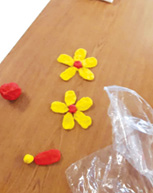 yellow and red playdough daisies made by residents