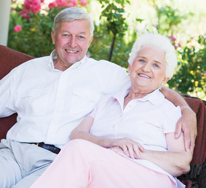 senior man and senior woman sitting on bench on a spring day in the park