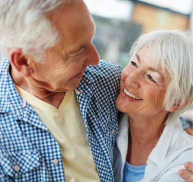 iStock photo of a senior man and woman smiling and looking at one another.
