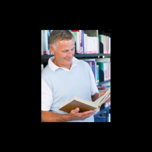 senior man reading a book in the library